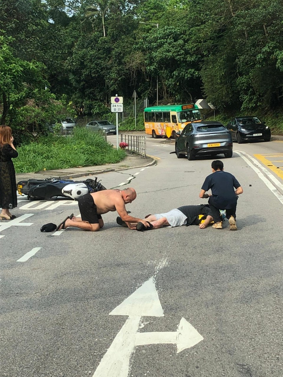 鐵騎士攤倒路上，外籍男子檢視其傷勢。網上圖片