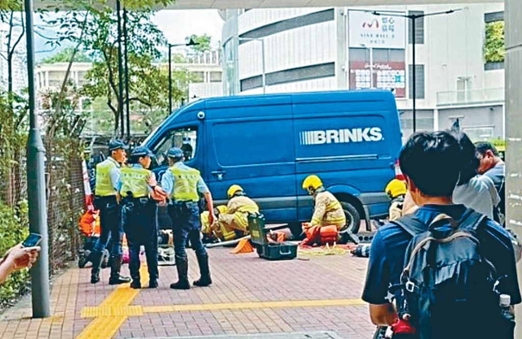 消防員利用工具升起解款車拯救被困車底女傷者。