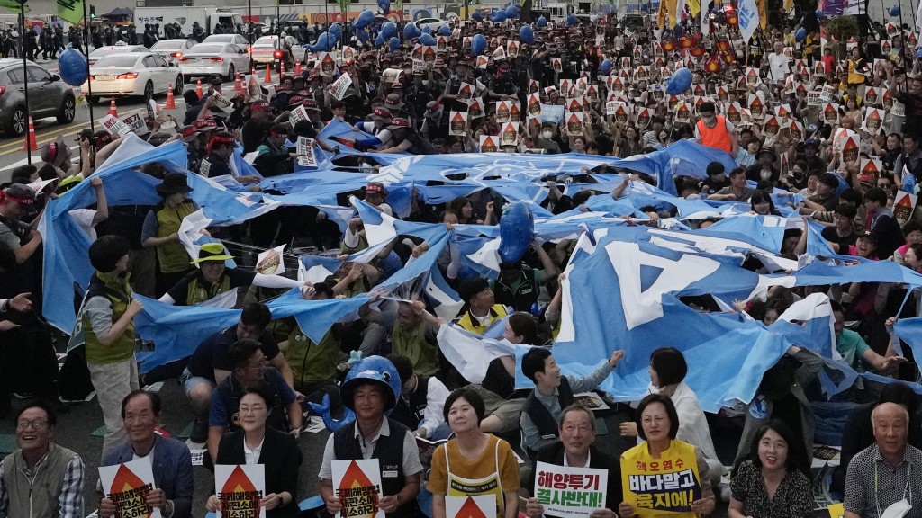 南韩示威者撕碎IAEA旗抗议。 美联社