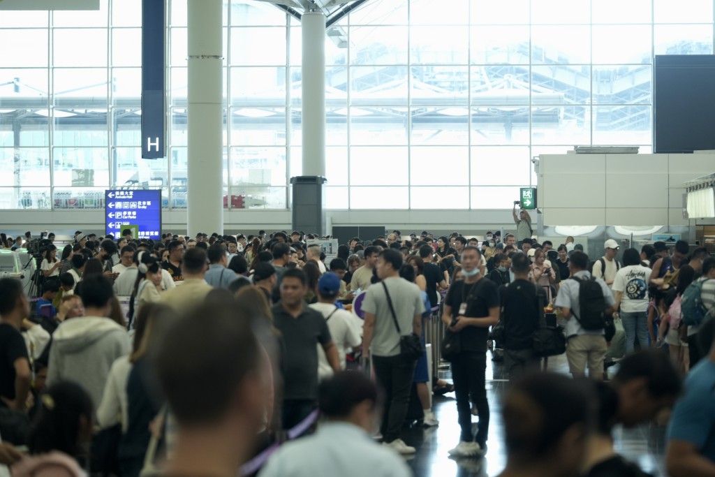 大批旅客在機場離境大堂等待。劉駿軒攝