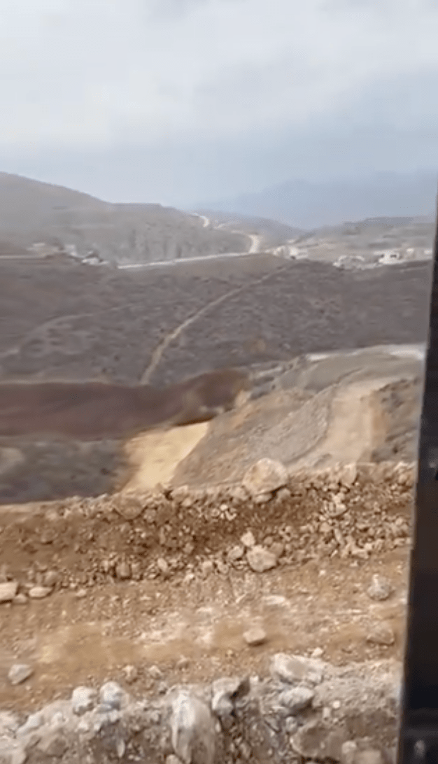网上流传一段矿场坍塌时景象的影片，大片泥土（深棕色部分）从山坡上倾倒流下，并不断扩散。