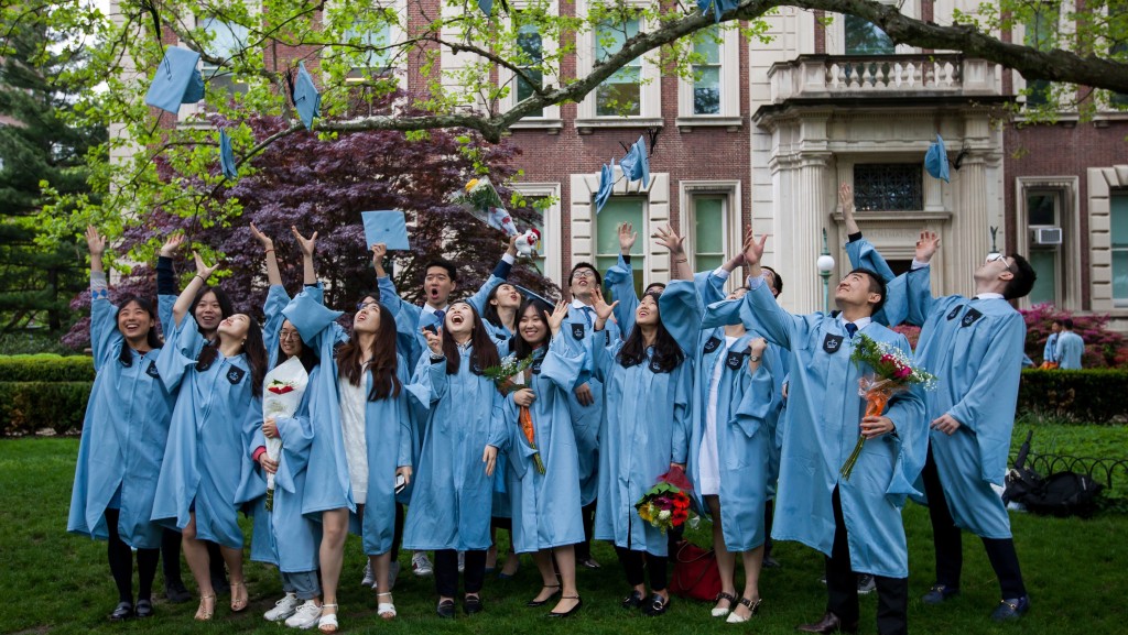 纽约哥伦比亚大学一群华人学生抛帽庆祝毕业。 新华社