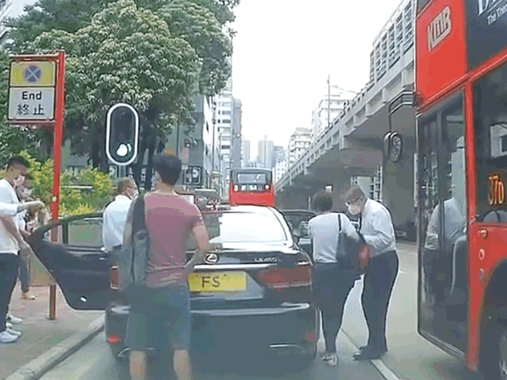 司機開門讓1男1女上車，身穿恤衫的男子相信為陳茂波。影片截圖