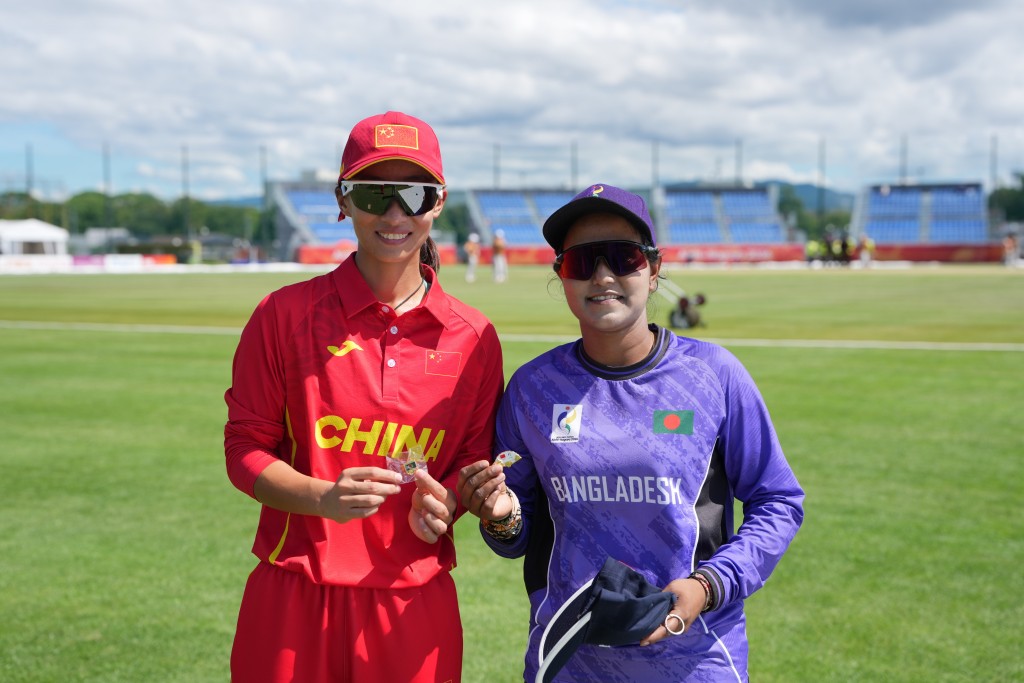 國家女子板球隊隊長朱明月（左）和孟加拉隊選手的合影。新華社