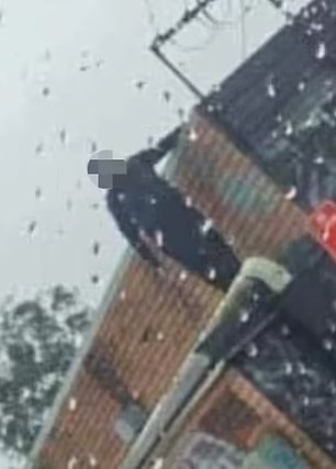 網傳一名黑衣人被攝到爬上漢堡包店屋頂。網圖 網傳一名黑衣人被攝到爬上漢堡包店屋頂。網圖
