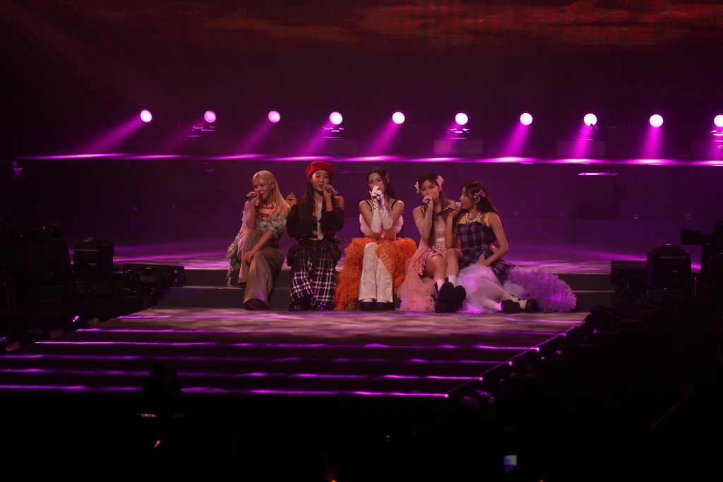 七女合體唱慢歌《Never-never Land》齊齊坐在台邊，着超短裙的Candy驚走光不斷用手按實裙邊。