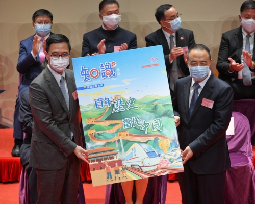 毛超峰(右)还代表紫荆文化将《百年历史．当代中国》特刊赠予教育局局长杨润雄(左)。