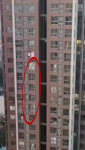 網傳鄭州男封控期間游繩落樓，畫面中出現一條白色疑似繩索的東西。