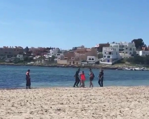 西班牙警察驅趕海灘遊客不果,遇反抗被推進海裏。(網圖)
