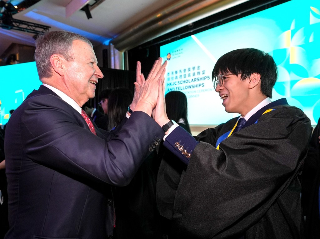 香港賽馬會行政總裁應家柏（左）恭賀賽馬會學人黃泓智（右）。