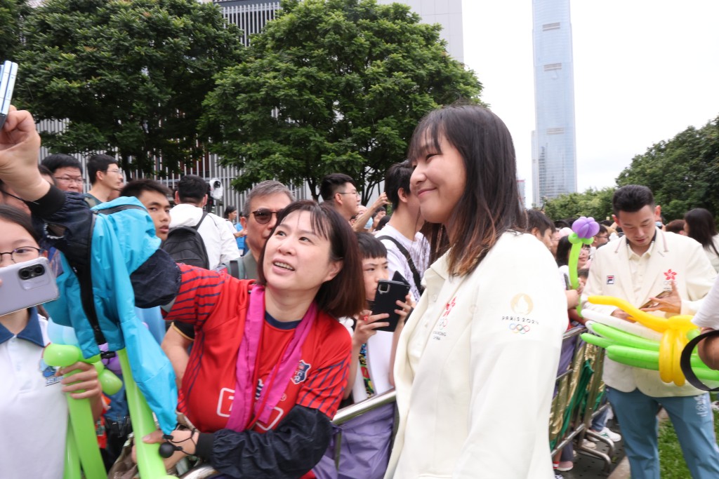   奥运港将参加胜利巡游，单车手李思颖与市民合照。徐嘉华摄