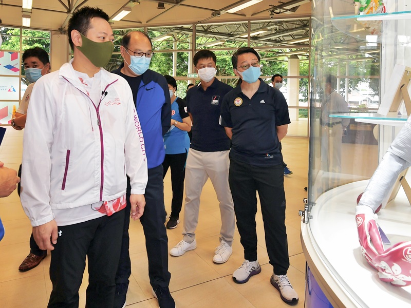 徐英偉(左二)觀賞不同運動的裝備,包括單車運動員李慧詩參賽時穿着的戰衣。