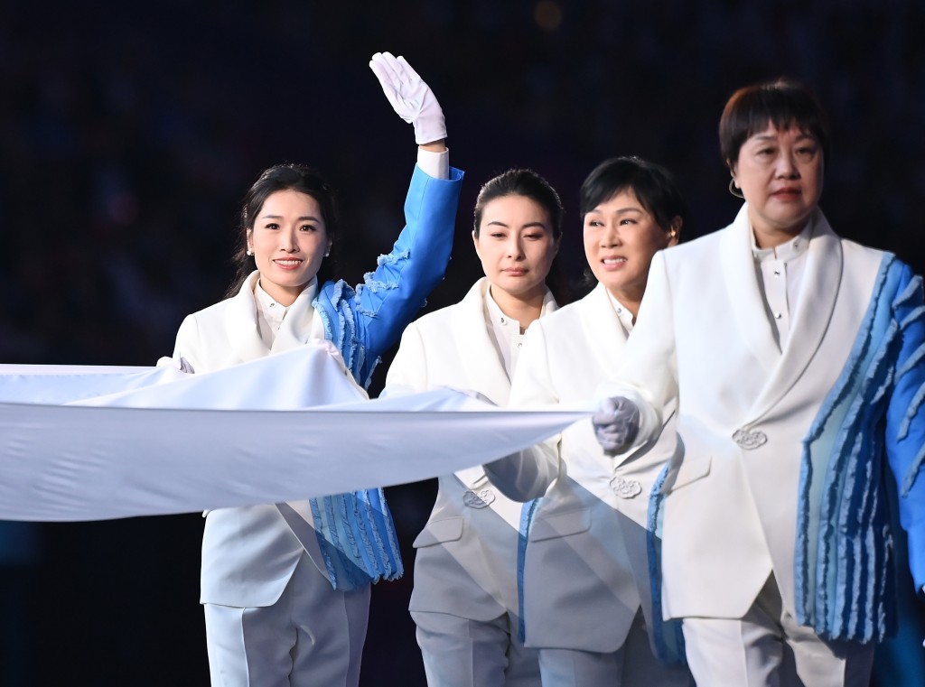 亞奧理事會會旗旗手羅雪娟（左一）在杭州亞運會開幕式上執旗入場。新華社