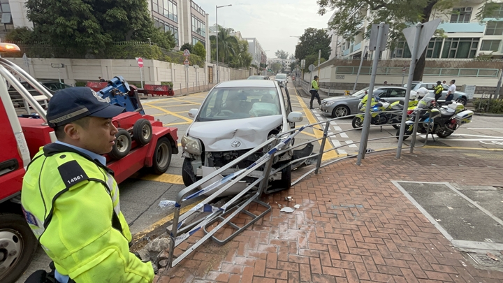 白色私家車撞向鐵欄。林思明攝