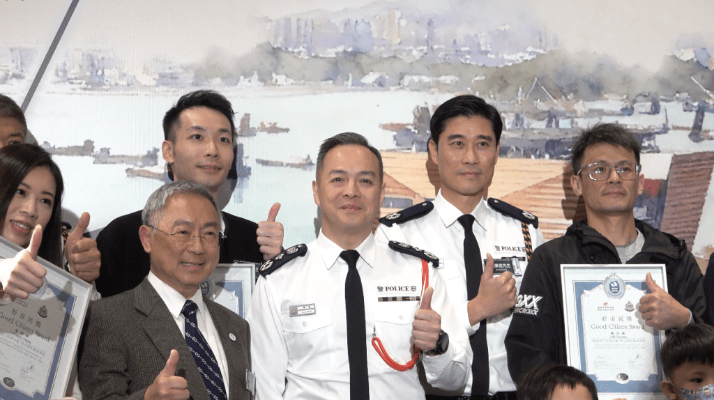 手機維修店主李浩權(上排左二)與警務處處長周一鳴(中)及西九龍總區指揮官吳樂俊(上排右二)在台後大合照。