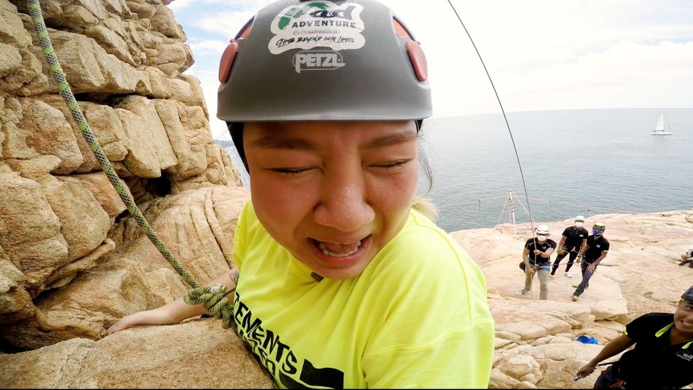 於垂直的懸崖上攀上十多米高崖頂，欣宜尖叫不斷。