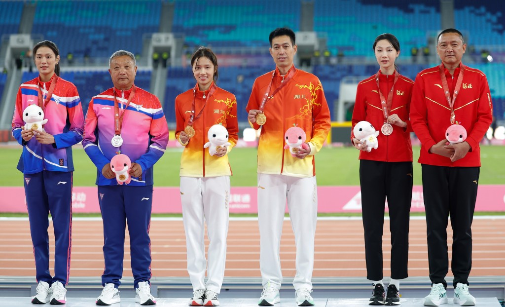 邵雨琪（中）獲得冠軍與教練在頒獎儀式上。 新華社