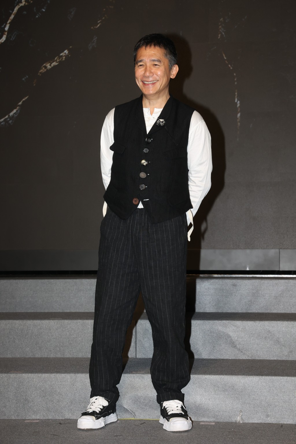 去年4月梁朝伟现身Filmart出席英皇电影新片巡礼，梁朝伟穿上日本设计师三原康裕的溶解鞋现身。