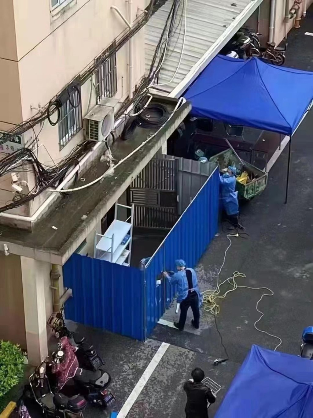 上海防疫人员在小区楼宇设置铁栅栏。网图