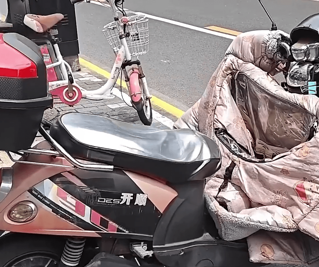 上海市民在電動單車鋪上防曬墊，防燙傷「屁股」。