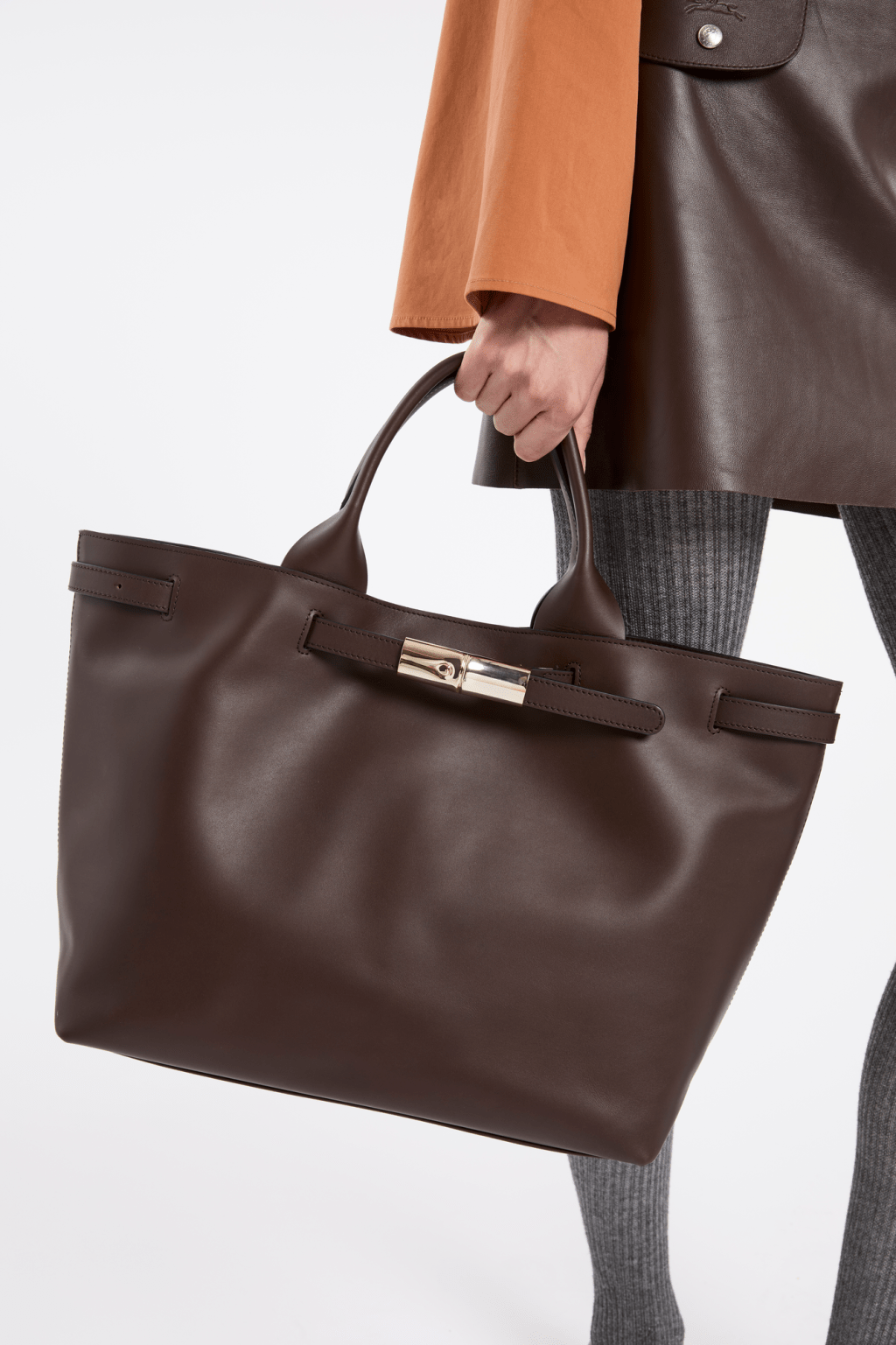 Tote Bag款式的皮革束带可改变袋口大小，饰以标志性的竹节扣饰。