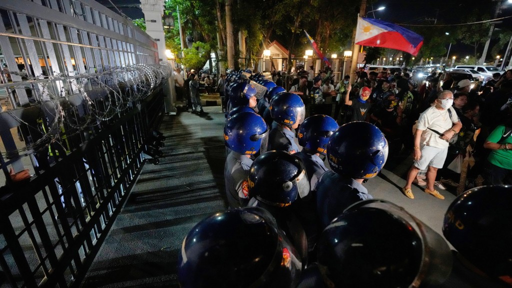 防暴警察包围议会建筑，隔开德拉罗沙支持者。 美联社