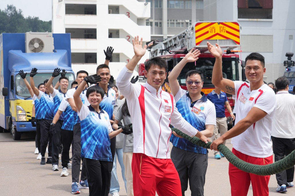 懲教署長黃國興帶領懲教人員同RPL，拍住靜水獨木舟男子雙人划艇500米奧運金牌得主季博文及劉浩，一齊拉動更生速遞教育宣傳車。