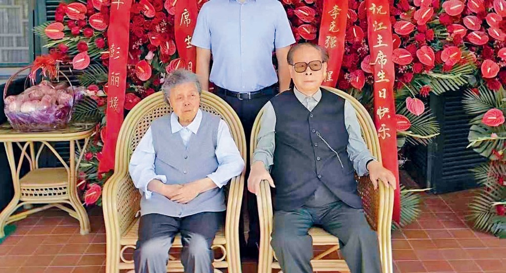 江澤民和夫人王冶坪合影,背後擺放着習近平、李克強送來的祝壽花籃。