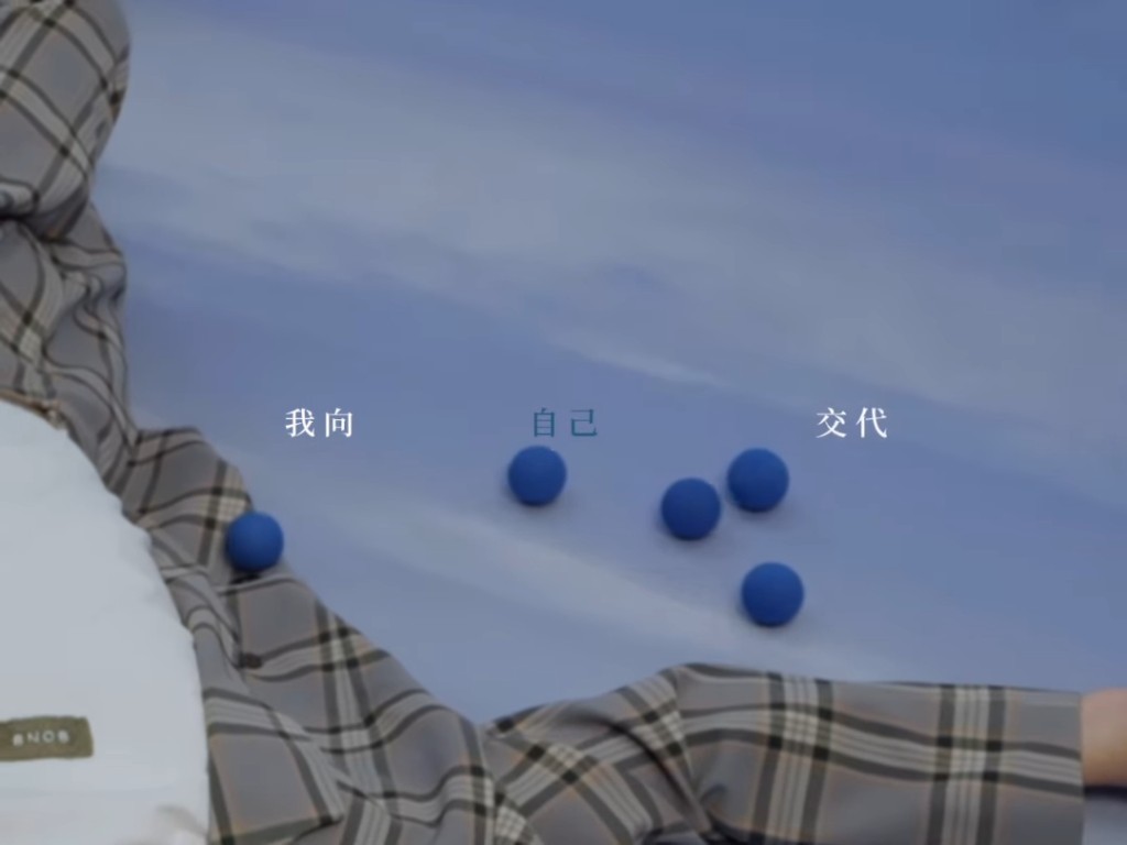 王祖蓝躺在地上，身旁有一堆小丑常用的蓝色小球。