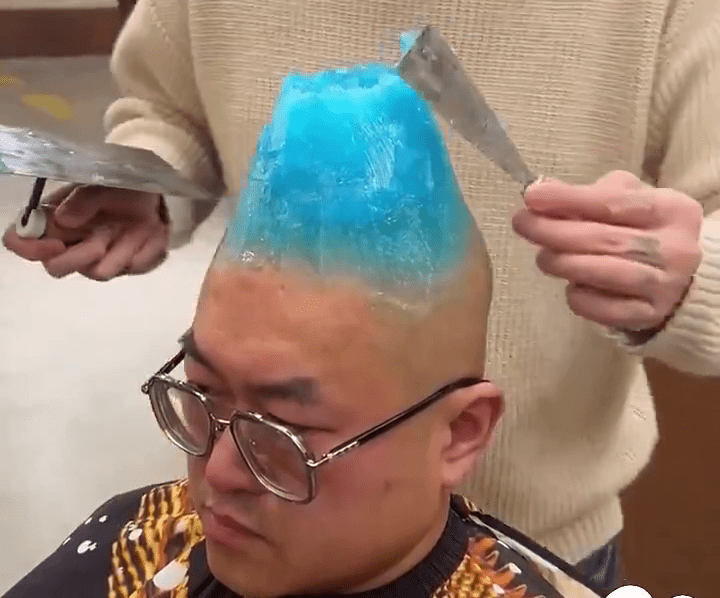 网片显示，彩蓝色的物料在光头男的头上堆出一座「火山」般的假发。