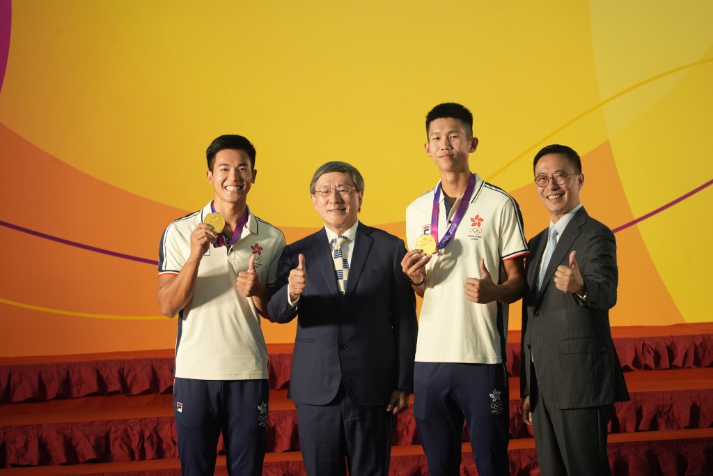 卓永兴（左二）、杨润雄（右一）与金牌健儿合照。吴艳玲摄
