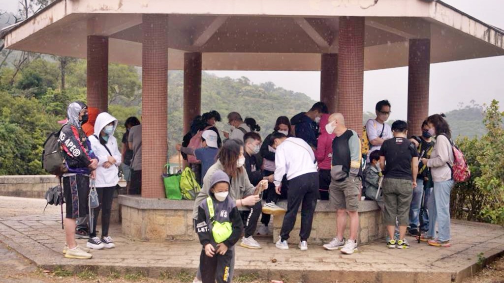 遊人在亭內休息，坐滿涼亭每一角。