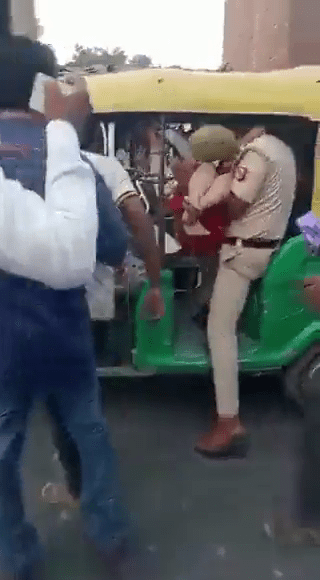 女童被警察抱到三轮车准备送到医院。