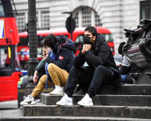 英國市民紛戴口罩出街防疫。AP
