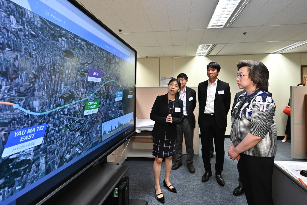 杨何蓓茵（右一）听取主要工程管理处人员介绍中九龙干线工程下开发的智慧工地管理平台。右二为路政署署长陈派明。