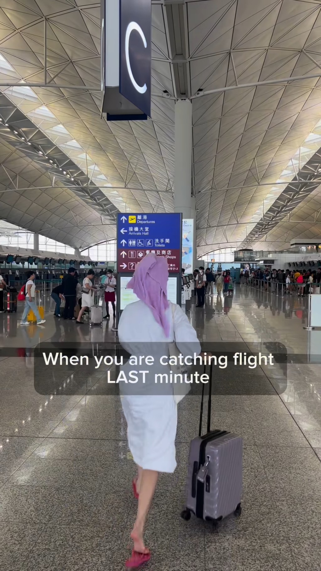 朱智賢頭上蓋着毛巾，身上穿浴袍，並穿上拖鞋於香港機場狂奔。