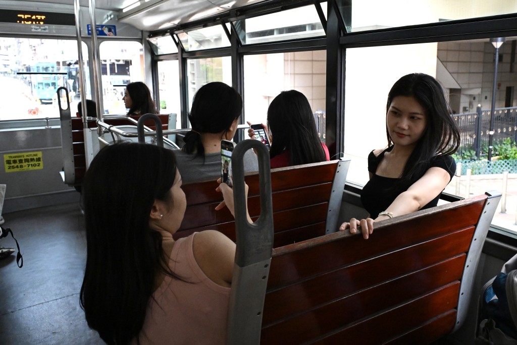 遊客在電車上拍照。