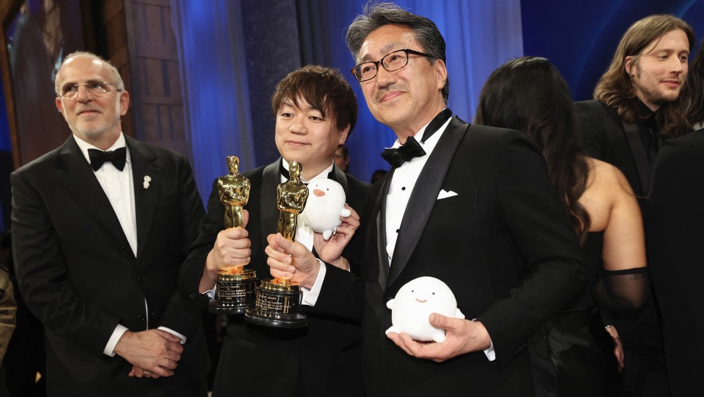 宫崎骏导演的《苍鹭与少年》勇夺奥斯卡，由动画师吉田健一（中左）与制片中岛清文（中右）代表领取「小金人」。 路透社