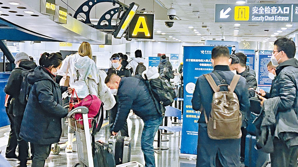 中國打開國門,首都國際機場旅客在國際及港澳台出發大廳排隊安檢。