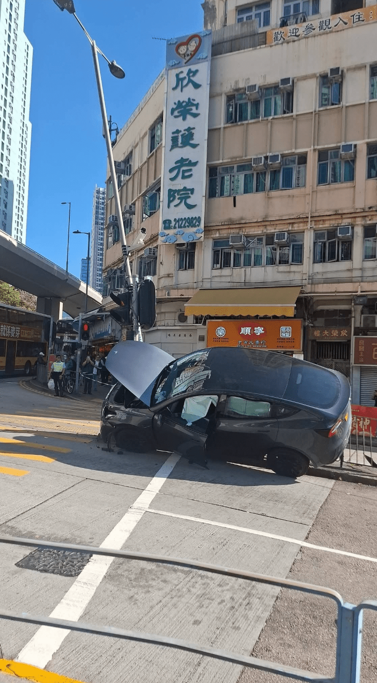 Tesla电动私家车先冲上路壆,再猛撼路旁灯柱,并波及约8米长铁栏。fb@香港公共交通智库 Tesla电动私家车先冲上路壆,再猛撼路旁灯柱,并波及约8米长铁栏。fb@香港公共交通智库