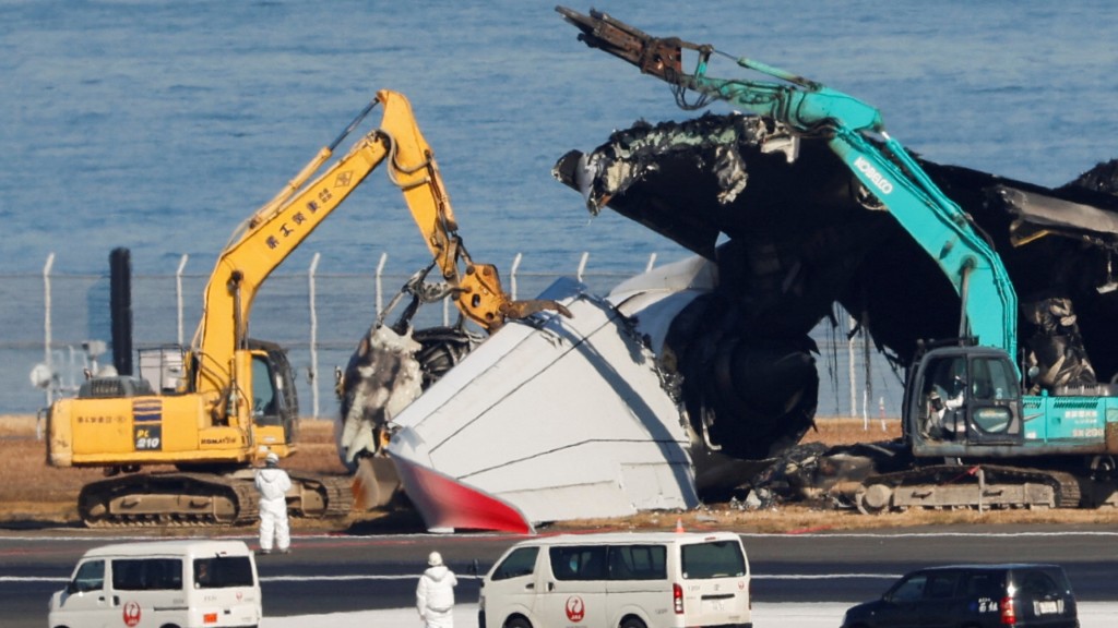 工作人员正逐步将出事日航JAL516客机的残骸从跑道移走。 路透社