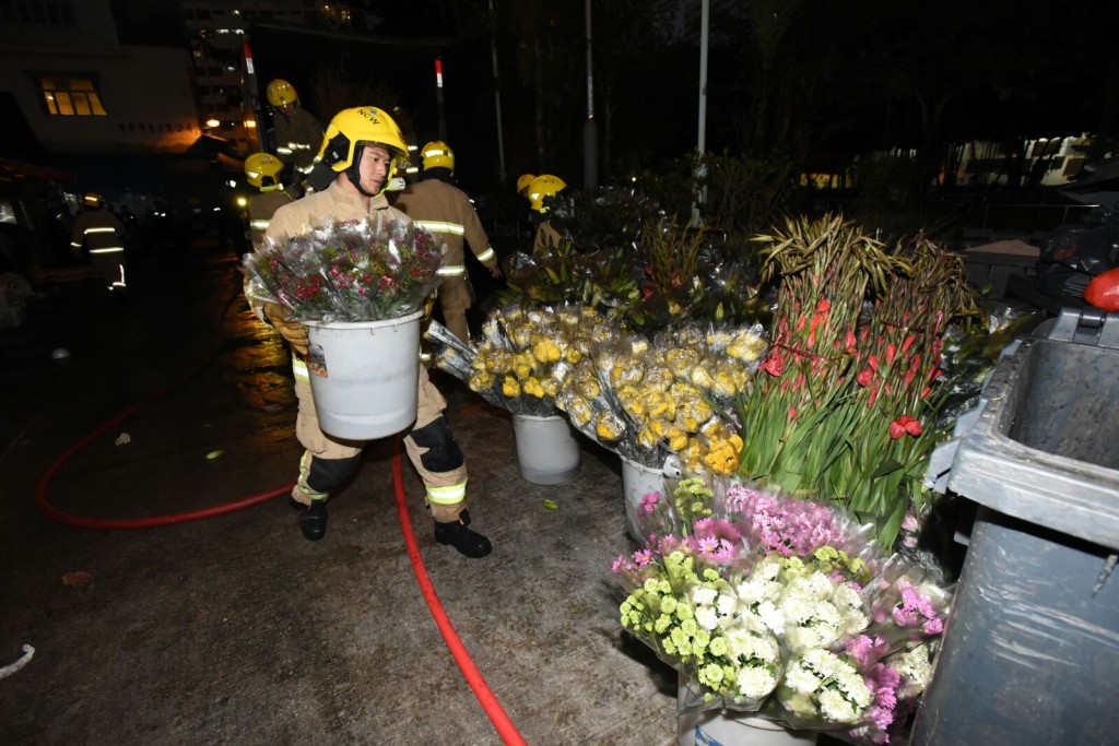 消防員將貨車上的鮮花搬到路邊。 羅振輝攝