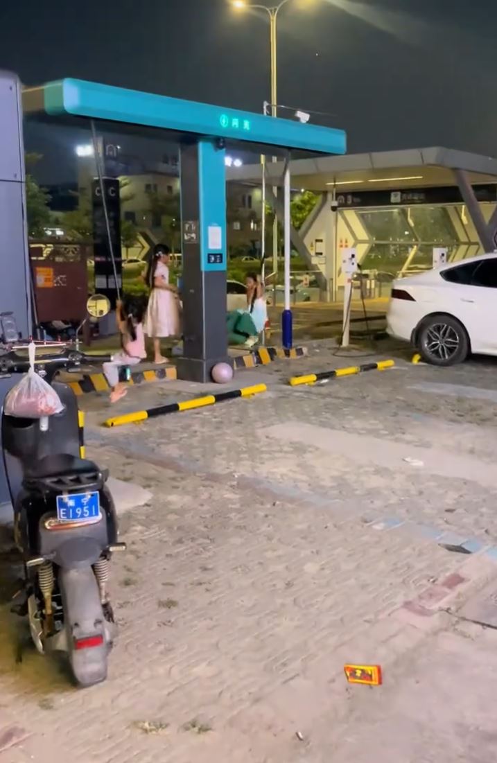广西有顽童将充电站电缆当秋千玩。微博