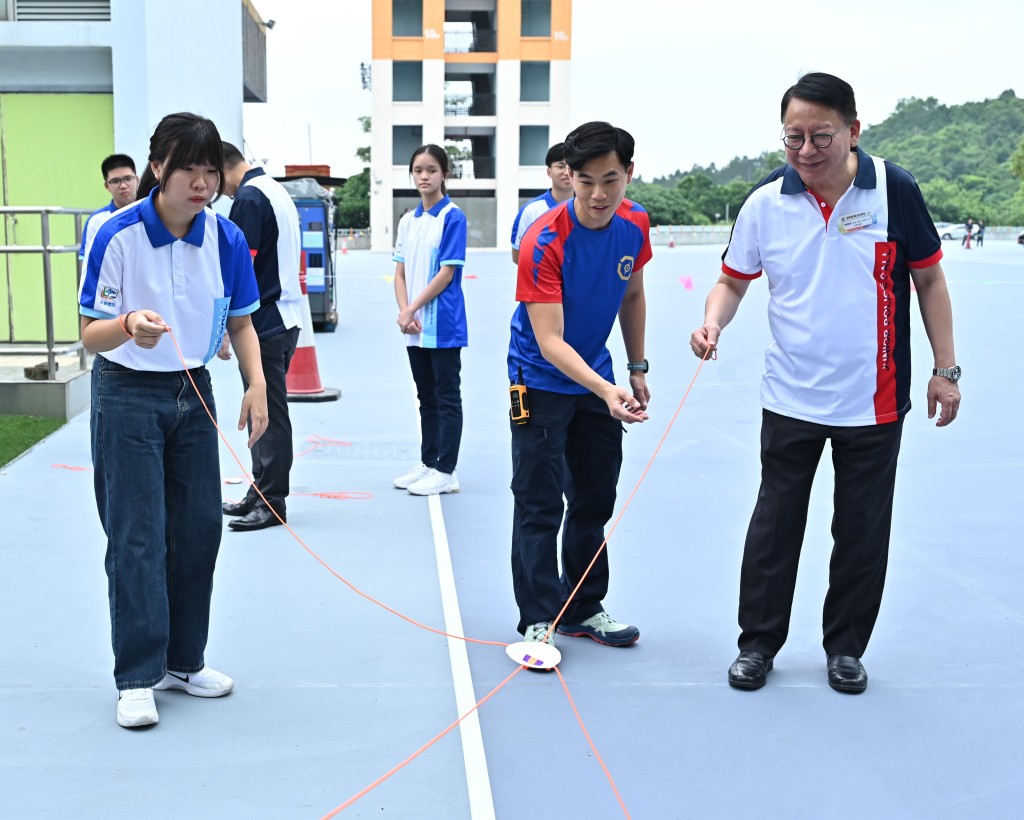 陈国基（右一）与参加者一起合作参与历奇游戏「运筹帷幄」。政府新闻处