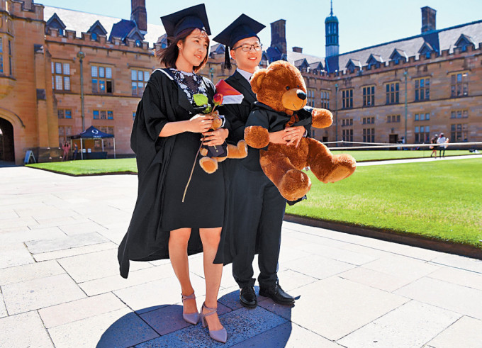 两名来自中国的留学生，在悉尼大学完成一个商业课程后，在校园拍照留念。网上图片