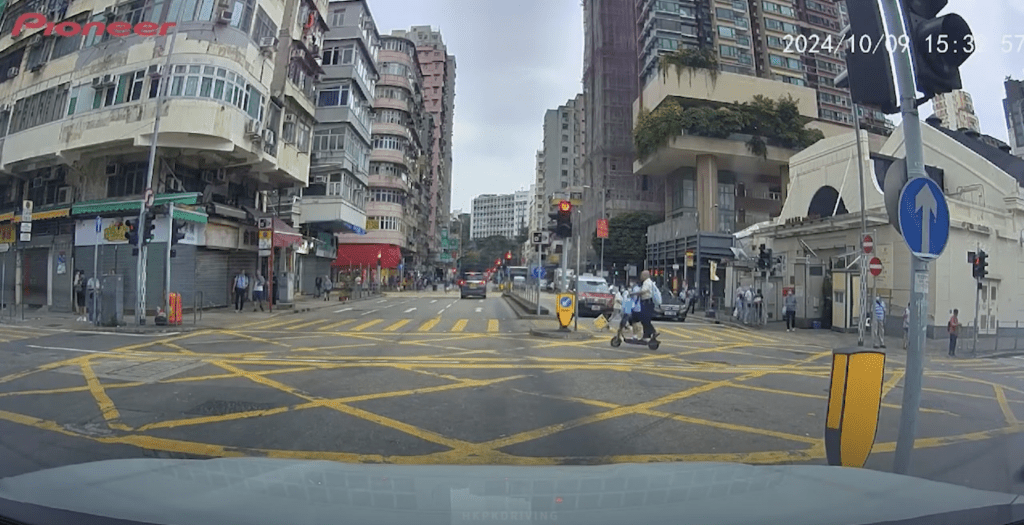 一名男子在油麻地馬路上，駕駛電動滑板車，並載有一名學童。Youtube 車Cam特警片段截圖