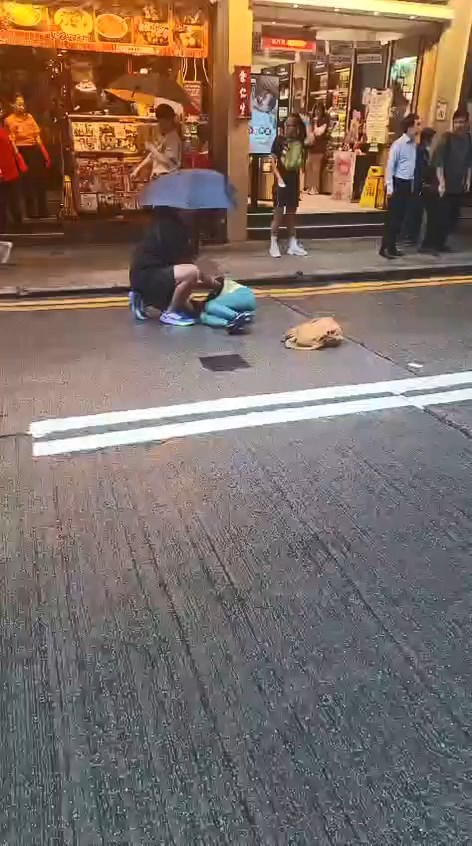林婦的兒子一邊舉傘一邊報警。網上片段截圖