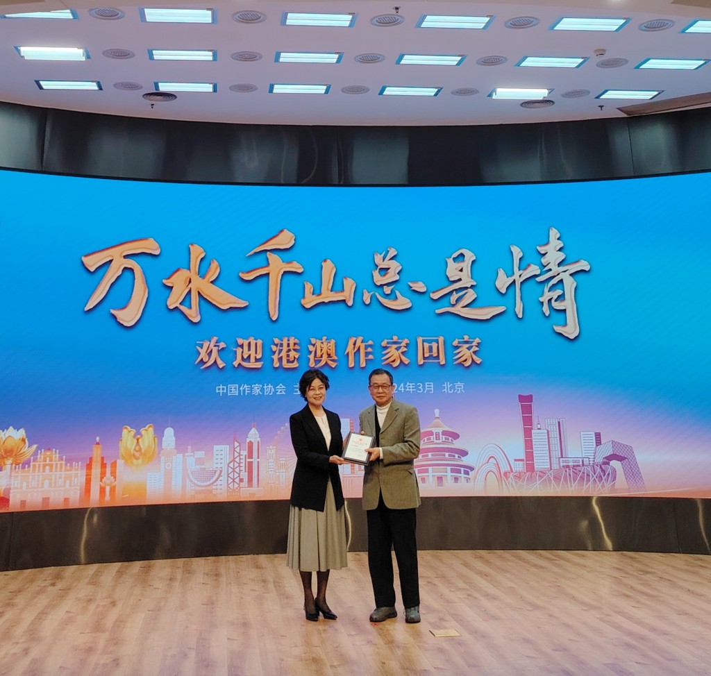 中国作家协会主席铁凝向香港作家联会会长潘耀明颁发纪念证书。 中通社
