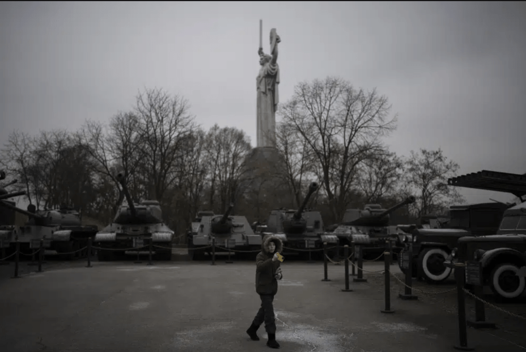 一個男孩在烏克蘭基輔的一個戰爭博物館為陳列的舊坦克拍照。(AP)