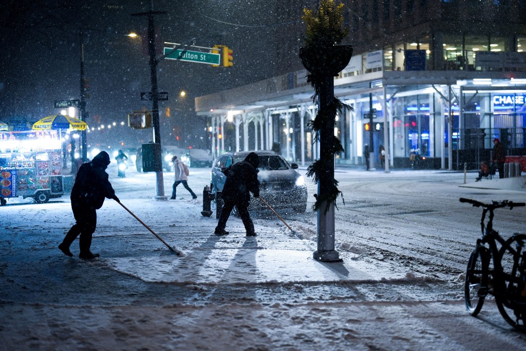 紐約工人忙於清理積雪。路透社